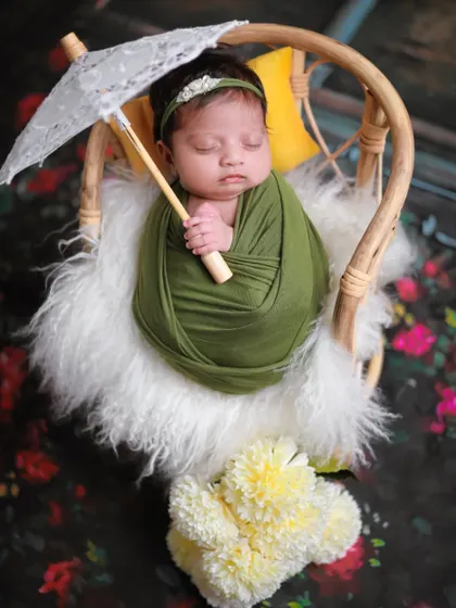 A similar setup with a green wrap and parasol, posed in a different chair to showcase the variety of props we offer.