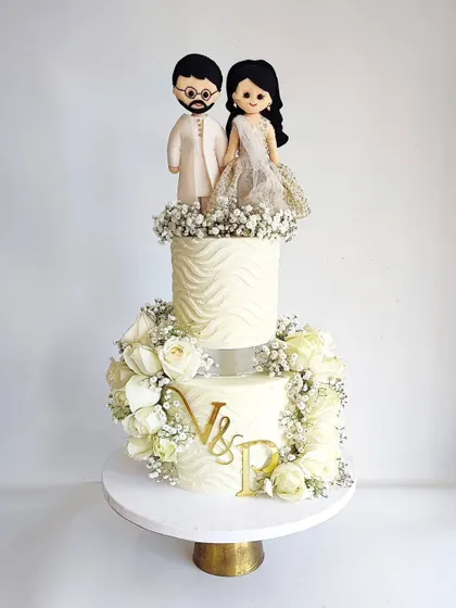 A similar design featuring a custom couple topper and beautiful white roses. This style is incredibly versatile for any romantic celebration.