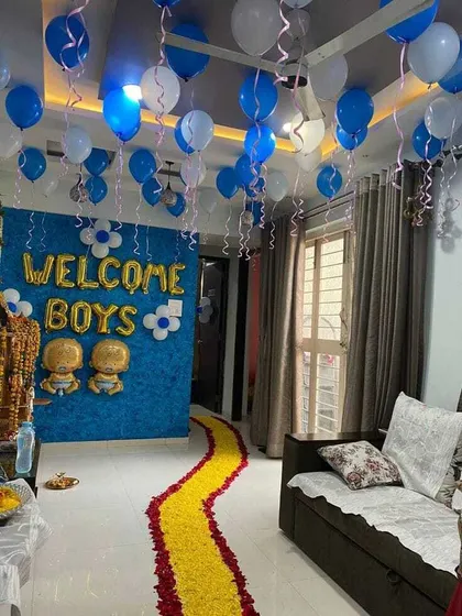 A 'Welcome Boys' home decoration for twin boys. A path of yellow flower petals leads into a room decorated with blue balloons and a custom wall backdrop.