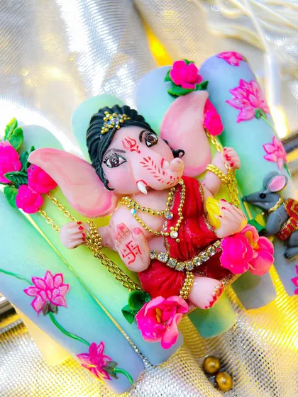 A close-up shot focusing on the sculpted face of Lord Ganesha, highlighting the intricate details like the jewelry, crown, and facial expression.