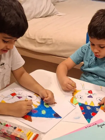 Here you can see two young brothers working side-by-side, each focused on creating their own version of a party cat. Our classes are a great activity for siblings to do together.