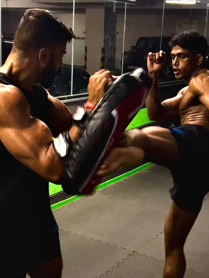 A perfect display of power and technique. One of our fighters executes a powerful kick during a pad work session, demonstrating the precision and force we cultivate in our striking classes.