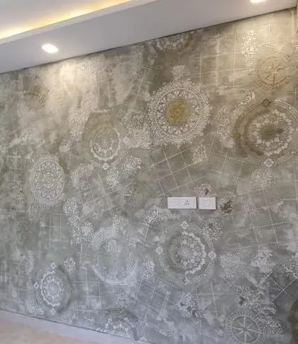 A highly unique wall finish combining a distressed concrete texture with intricate white mandala and compass stencils for a vintage, worldly look.