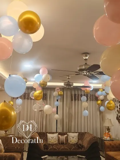 A room filled with pink, blue, and gold balloons floating on the ceiling, creating a festive and celebratory atmosphere for a baby shower.