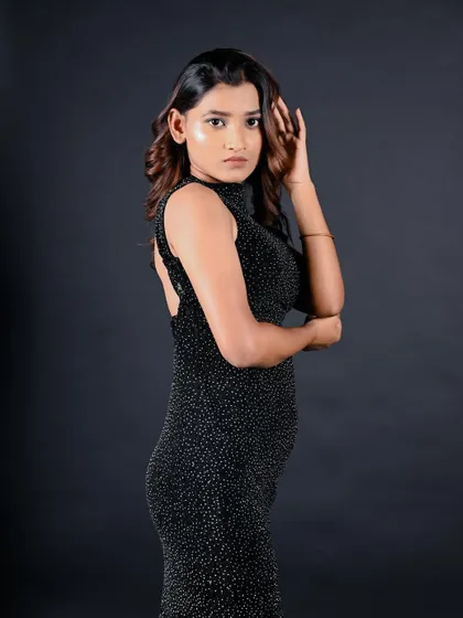 A profile shot that showcases the backless design of the dress and the model's elegant posture.