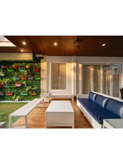 Another view of the balcony with the vibrant vertical garden. This angle shows the comfortable seating arrangement, perfect for enjoying a calm, cozy moment at any time of day.