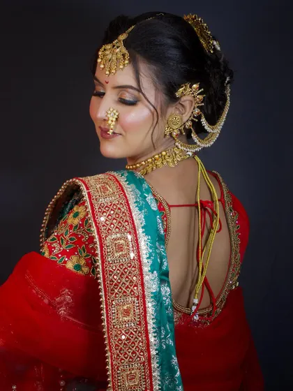 A back profile showing the beautiful blouse design and the neat finish of the bridal bun and saree draping.