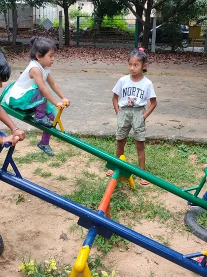 Children learning to coordinate their movements on the seesaw at the park. This requires communication and cooperation, making it a great social learning activity.