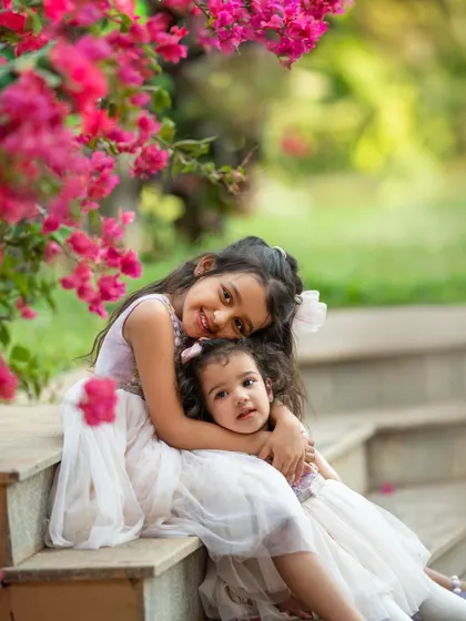 The bond between sisters is just magical. Capturing this sweet hug under the bougainvillea was such a joy. These are the unposed, genuine interactions that I live to photograph during our outdoor sessions.