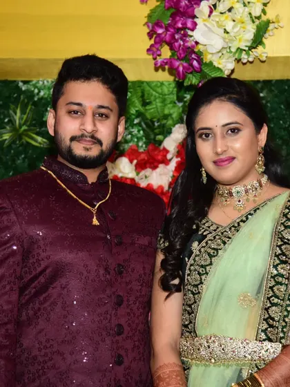 The bride and groom at their reception. She is wearing a beautiful green Kundan and polki set, also available for rent.