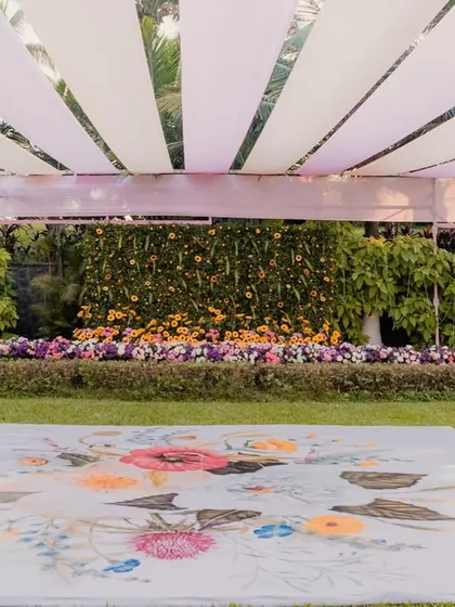 A wide view of a garden Haldi setup, featuring a custom-printed floral dance floor. This unique detail adds a personalized touch and enhances the overall theme of the event.