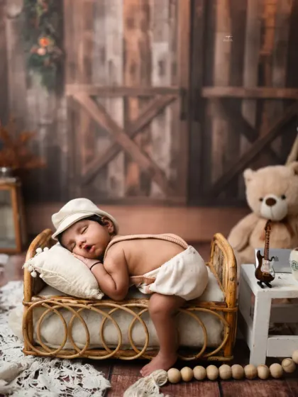 A newborn naps on a miniature cane bed, creating a cozy and rustic scene. I ensure every pose is safe and comfortable for your little one.