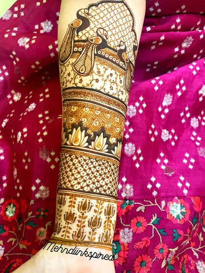 A full view of the doli bridal mehndi, extending up the arm. This angle shows the beautiful peacock and lotus bands that complement the main scene on the palm.