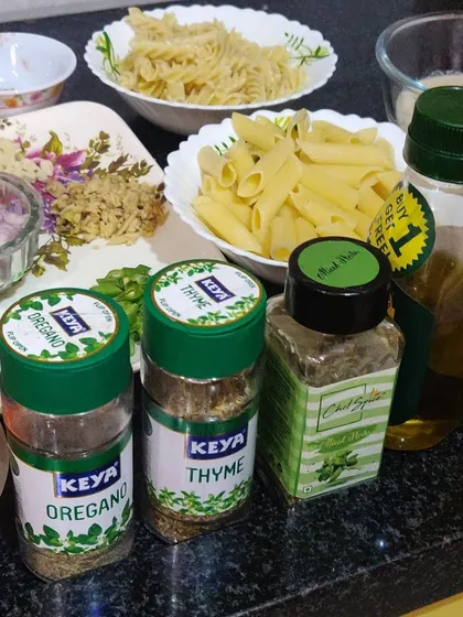 The fresh ingredients I use for my pasta dishes, including penne, fusilli, herbs like oregano and thyme, and quality olive oil.
