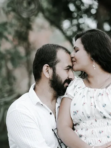 An intimate close-up of a bride kissing her groom's forehead, capturing a tender and affectionate moment.