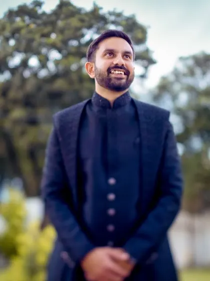 A candid shot of the groom looking up with a happy smile, captured during his engagement ceremony. We make sure to get great solo portraits of the groom too.