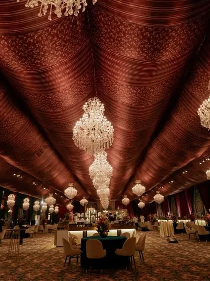 A perspective shot down the length of the grand dining hall, emphasizing the endless line of sparkling chandeliers that create a ceiling of light. The scale and opulence are designed to leave a lasting impression.