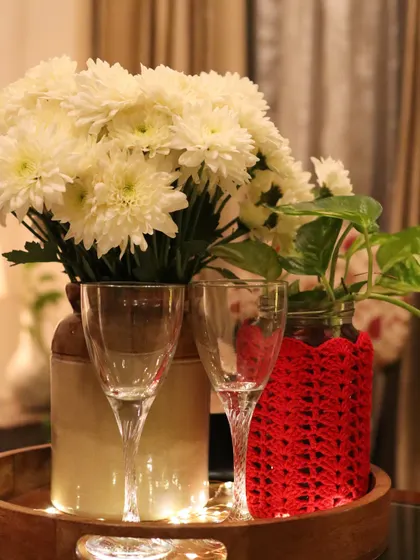 A simple Christmas vignette. This red crochet vase cover adds a pop of festive colour to a quiet corner, paired with fresh white flowers.