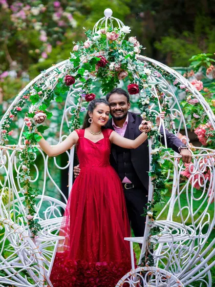A joyful photo of a couple in a beautiful, white, floral-adorned carriage, perfect for a fairytale theme.