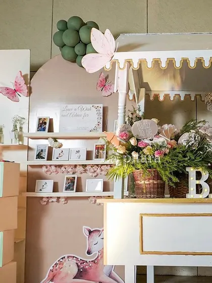 The full wishing wall and favor station, decorated with woodland creatures and pastel colors.