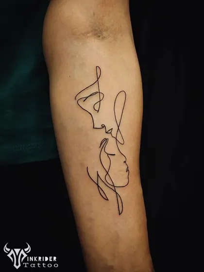 The beauty of minimalism is in its power to convey deep emotion with simple forms. This continuous single-line tattoo captures the intimacy of two faces, creating an abstract yet profoundly connected piece of art on the forearm.