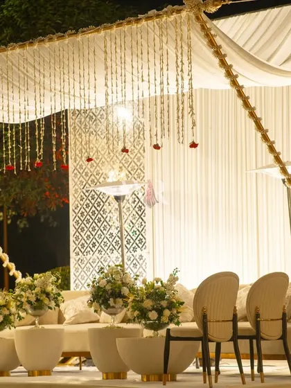A serene corner of the reception, featuring a canopy of hanging mogra. The ivory paneling, floral ottomans, and plush seating created a space of intentional stillness and traditional beauty.