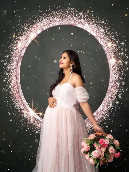 A touch of sparkle for a magical portrait. This mom-to-be looks ethereal in a soft pink gown, framed by a glittering ring of light.