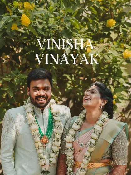 A happy portrait of the South Indian couple, Vinisha and Vinayak, adorned with beautiful floral garlands.