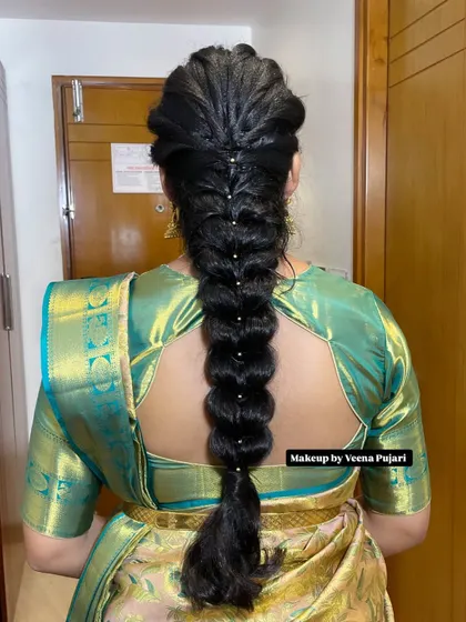 A modern take on a traditional braid. This fishtail braid is decorated with delicate pearls, offering a chic and elegant option for a wedding or reception.