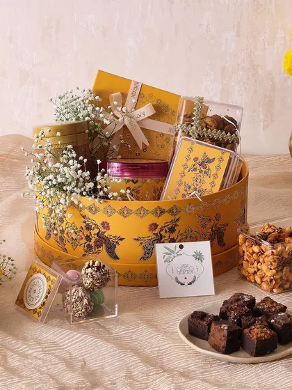 Our Golden Glow Hamper is a festive selection of brownie bites, various nuts and trail mixes, chocolate truffles, and sugar-free mithai.