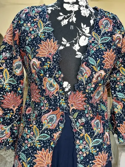 The jacket has a beautiful scalloped edge, adding a delicate touch to the bold print.