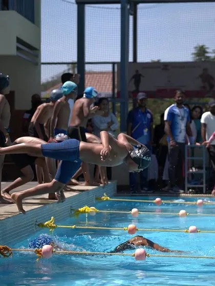The determination on a young swimmer's face as he prepares to launch off the starting block.