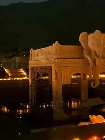 A view of the elephant-themed mandap structure during setup, surrounded by water and diyas. This image captures the calm before the storm and the magic of seeing a vision come to life.