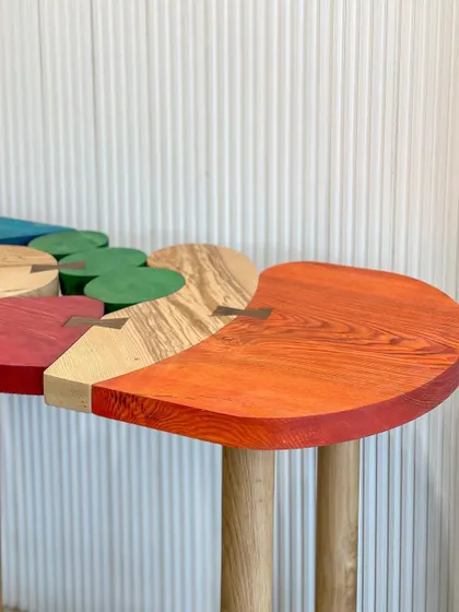 A detail shot of the "Doodle Console," showing the intricate butterfly joinery and the beautiful wood grain visible through the colorful stains. This highlights the level of craftsmanship involved.