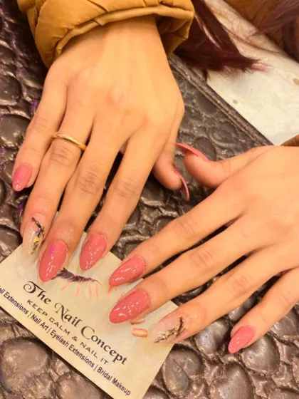 A beautiful set of long, stiletto nails in a dusty rose color. The accent nails feature a sheer base with an abstract design made from black lines and gold foil.