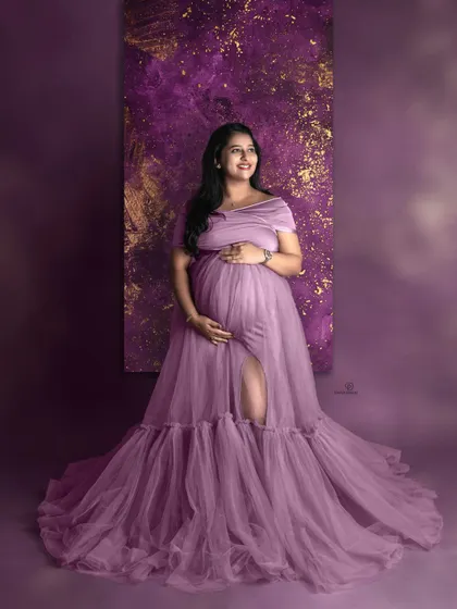 A vision in purple. This mom-to-be shines in a flowing tulle gown against a matching textured backdrop, showing how we can play with color for a bold and beautiful studio look.