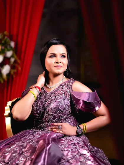 A poised and elegant portrait of the bride-to-be. Her upward gaze and graceful posture, combined with the rich purple of her gown, create an image of regal confidence.