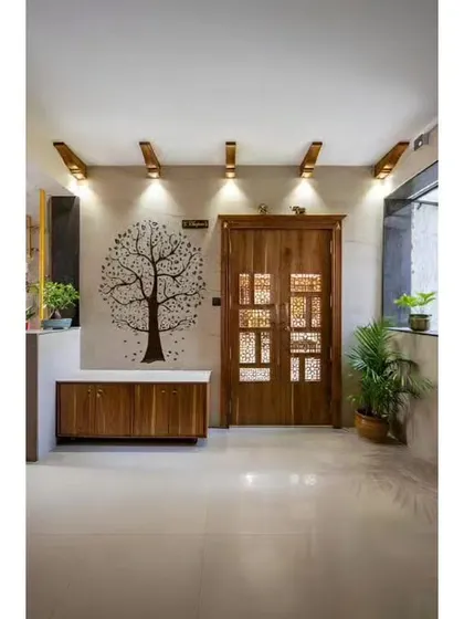 A beautiful entryway with a traditional carved wooden door and a tree of life wall decal. A simple wooden cabinet provides storage, creating a warm and inviting first impression.