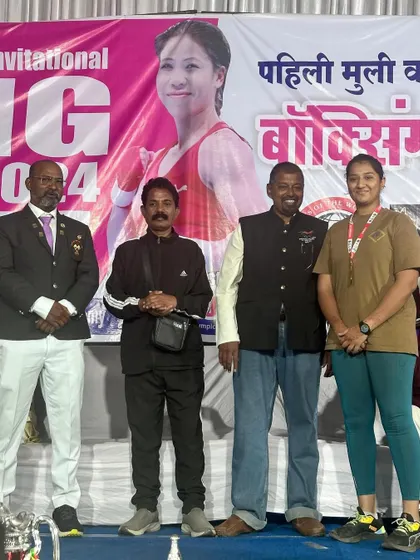 Our coach and boxer Prisha Pawar standing with officials after her gold medal win at the National Boxing Championship in Bhusawal. We ensure our fighters get exposure to high-level competitions.