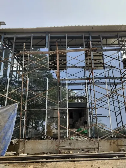 The glass facade of the Experience Center reflecting the sky, even while surrounded by scaffolding.