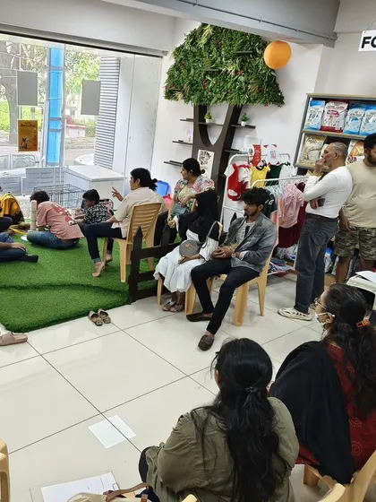 A wide shot of our cat adoption drive, with people sitting on the floor to be at the cats' level, creating a non threatening and comfortable atmosphere.