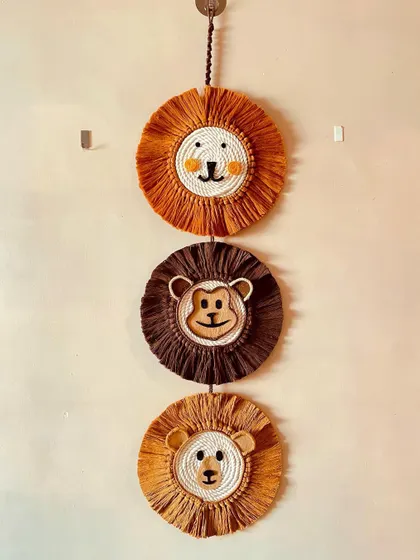 A vertical wall hanging featuring a trio of jungle animal faces. This piece includes two lions and a cheeky monkey in the middle.