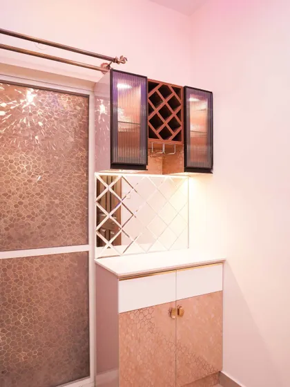 A stylish bar or crockery unit with a rose gold finish, diamond-mirrored backsplash, and integrated wine racks. This piece is perfect for entertaining.