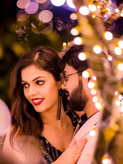 An intimate portrait of a couple framed by fairy lights, showcasing their connection and the romantic ambiance of the evening.