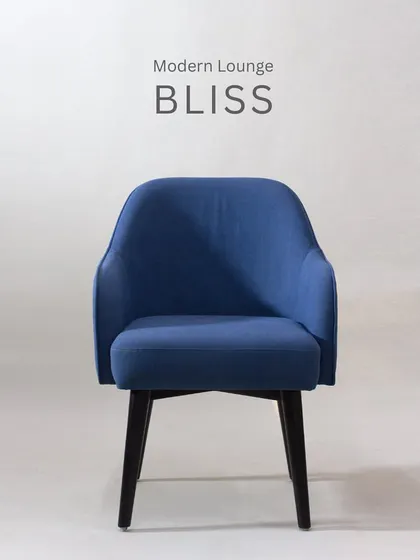 This modern lounge armchair in a deep blue fabric is perfect for creating a cozy reading nook. Its curved back and arms provide an enveloping sense of comfort.