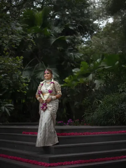 The bride making her entrance down a flower-strewn staircase. This shot captures the grandeur of the moment and her graceful presence.
