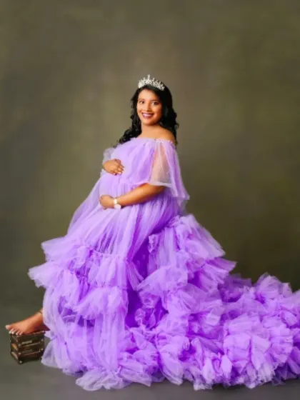 Feel like a true princess in this off-the-shoulder lavender tulle gown. The soft ruffles and expansive train create a dreamy and elegant look.