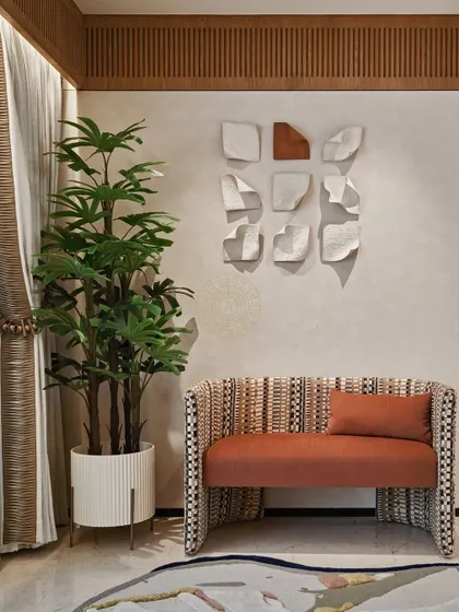 We create cozy corners in every home. This seating nook features a custom bench with a unique woven pattern and a burnt orange cushion, complemented by minimalist paper-like wall art.