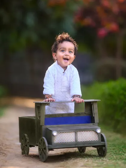 Standing tall and proud in his little truck. This shot captures a moment of excitement and confidence during a pre-birthday photoshoot.