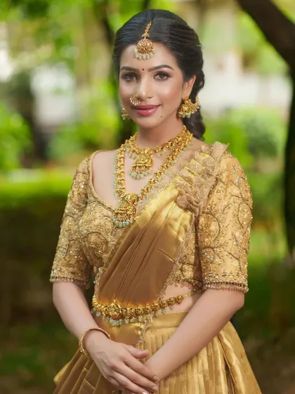 This all-gold bridal set is for the bride who loves pure, classic elegance. The intricate workmanship on the necklace, haram, and vaddanam shines through, creating a look of timeless sophistication.